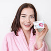 Vrouw met Diamond Smile tand whitening PAP+ poeder voor het poetsen van haar tanden in haar hand