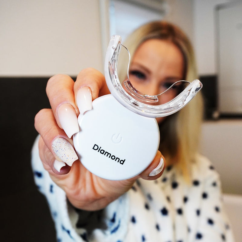 Vrouw met Diamond Smile Paarse kleurcorrectie tandbleekset - Paarse bleekset in de hand